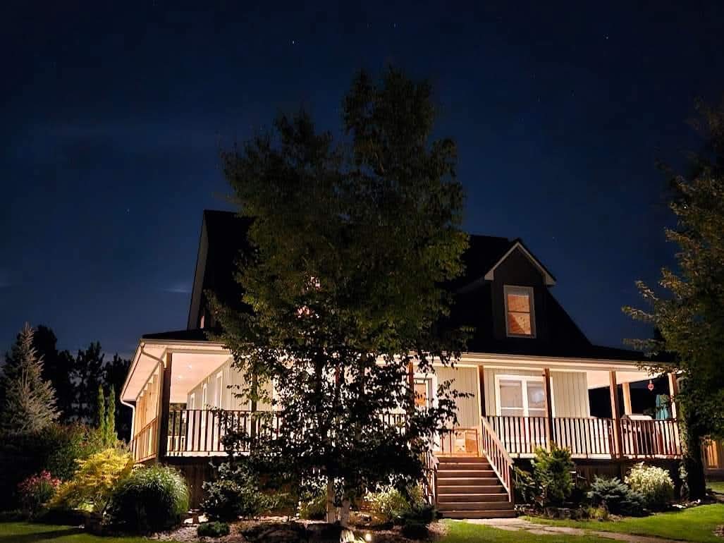 Cottage at night with wrap-around porch